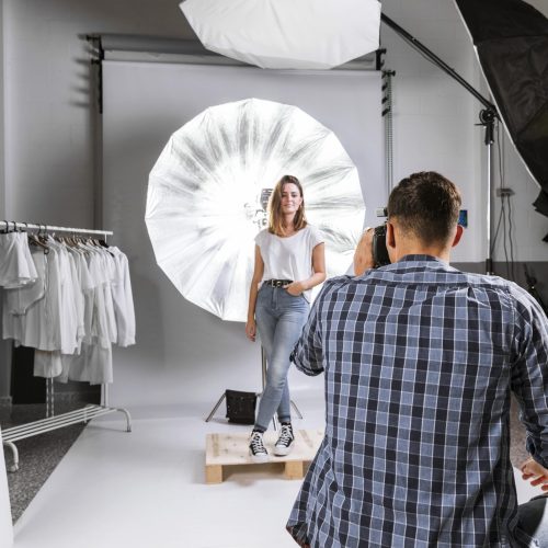 man-taking-photo-woman-model-studio
